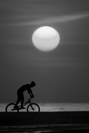 bmx rider action against sunset on the beach.の写真素材