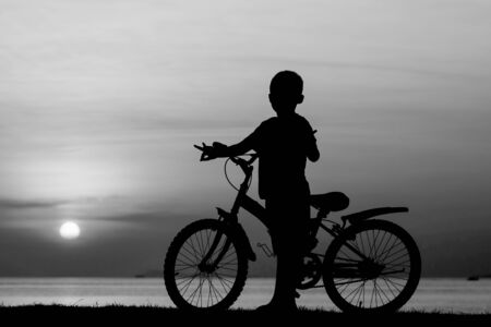 Silhouette of a boy on the beach during sunset.の写真素材