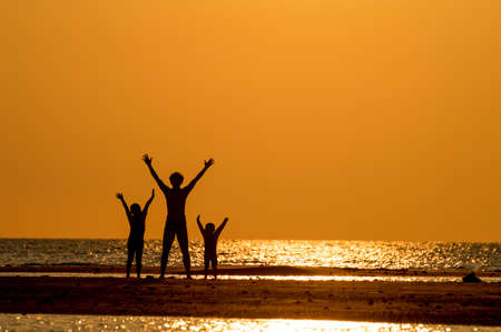 silhouette of happy family at sunset.の写真素材