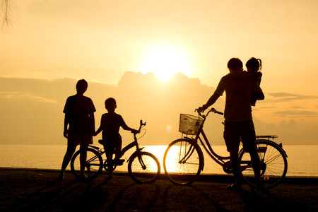 Biker family silhouette , family on the beach at sunset.の写真素材