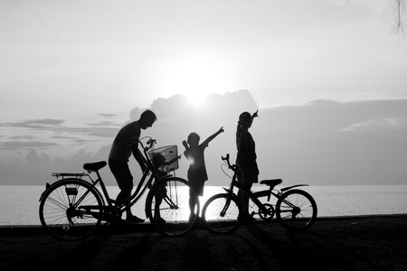 Biker family silhouette , family on the beach at sunset.の写真素材