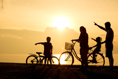 Biker family silhouette , family on the beach at sunset.の写真素材