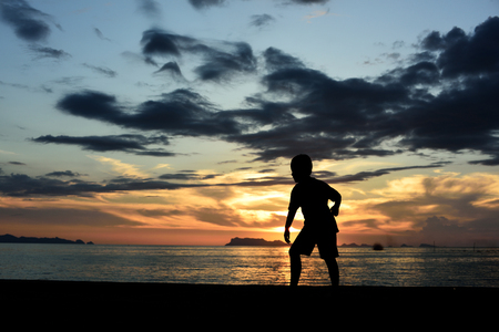 Silhouette life and activity on the beach at dusk.の写真素材