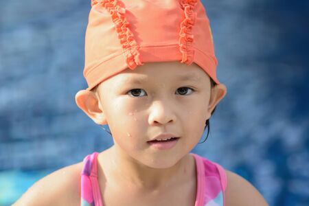 Small asian kid in swimming suit at the pool.の写真素材