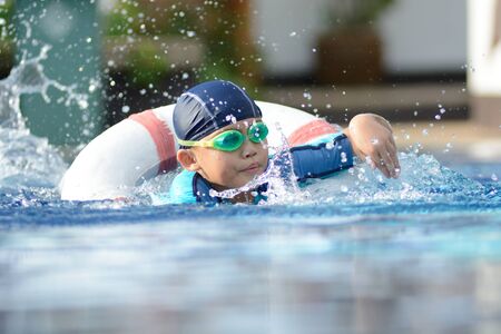 Small asian kid in swimming suit at the pool.の写真素材