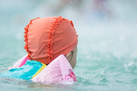 Small asian kid in swimming suit at the pool.の写真素材