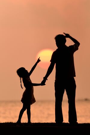 silhouette happy family at sunset.の写真素材