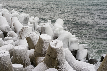 Breakwater covered by ice on a background a seaの写真素材