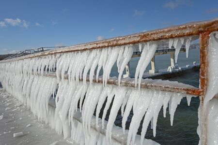 Row of icicles on the background of the seaの写真素材