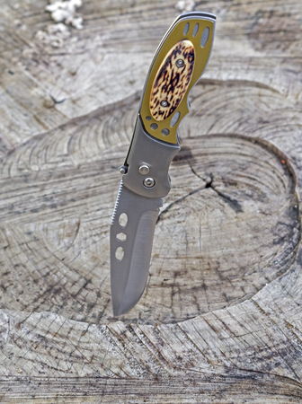 Pocket knife on a wooden background
