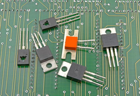 Closeup detail of six transistors on circuit board
