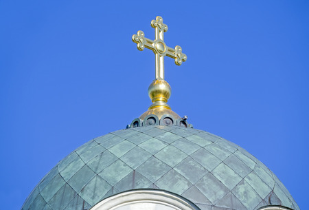 The dome of the Church with a cross against the blue sky