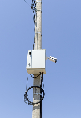 Security cctv surveillance camera in front of blue sky