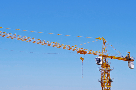 yellow construction crane tower on background of blue skyの写真素材