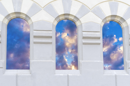 closeup of vertical windows of church with a picture of the skyの写真素材