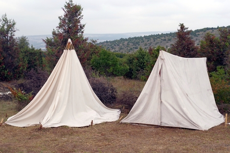 white tents set in the summer forest