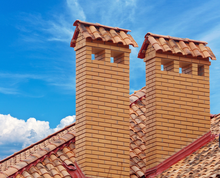 brick smokestack isolated on background of blue skyの写真素材