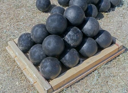 A pyramid of black cannonballs on the grassの写真素材