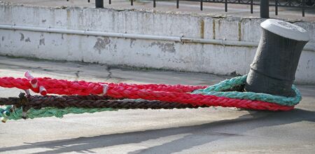 ship mooring lines attached to bollard on pier