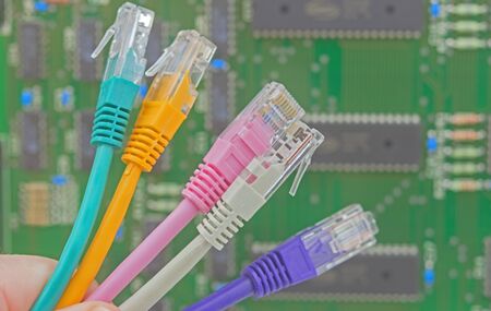 multicolored network connector wires on background electronic circuit board