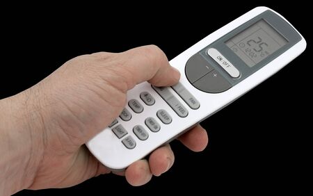 Remote control of air conditioner in the hand on black background
