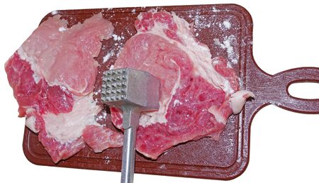 Fresh pork tenderloin with a metal hammer for beating meatの写真素材
