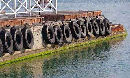car tire with a metal chain on a old concrete sea pierの写真素材