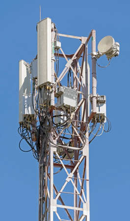 Tower with aerials of cellular on a background blue sky