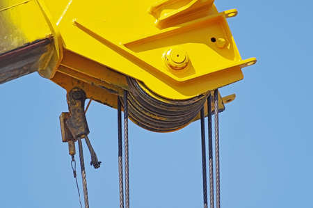 close up at top beam of crane mobile on background of blue sky