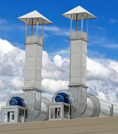 large industrial shiny metal pipes against the blue skyの写真素材
