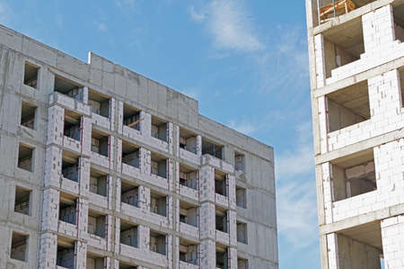 High-rise building under construction against blue sky
