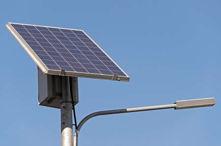 Street Light powered by a solar panel with a battery against blue sky