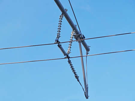 Contact wires of a trolley bus against a blue sky