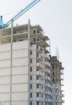 Building crane and building under construction against sky