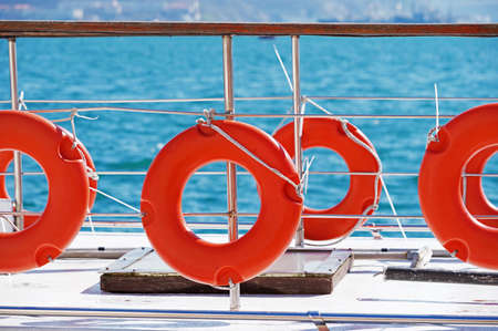 Orange lifebuoy attached to board the ship