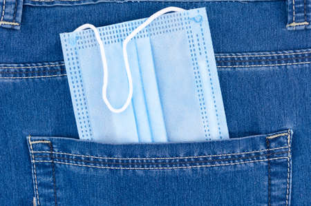 medical face mask in new blue jeans pocketの写真素材
