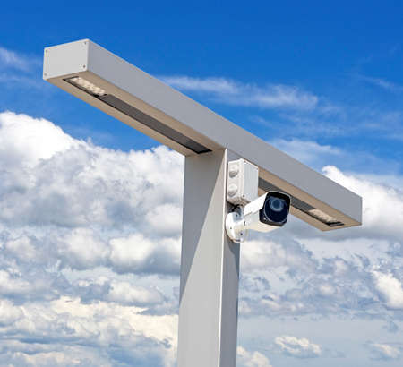 IP security camera and led Street lantern mounted on post against the blue skyの写真素材