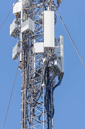 Tower with aerials of cellular on a background mountains and blue sky