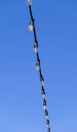 a garland of lamps on a blue sky background