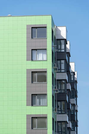 Modern, new highrise residential building in city on background of skyの写真素材