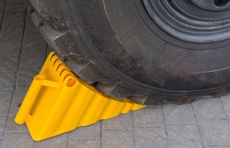 the wheel chock under the wheel of a car