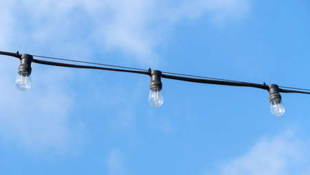 a garland of lamps on a blue sky background