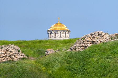 a cross on top of a Christian church on the background of sky