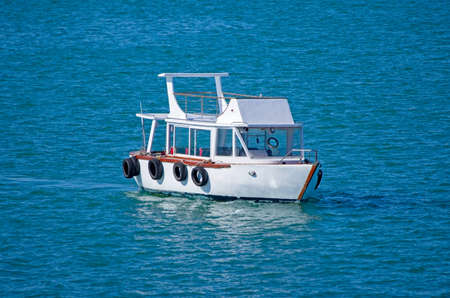 little white motor boat in the middle of the blue deep ocean