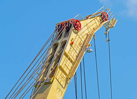 Detail from a floading cargo crane over blue sky backgroundの写真素材