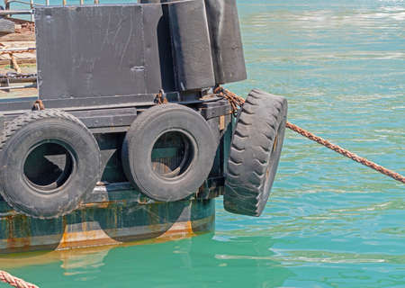 car tire with a metal chain on a old concrete sea pier