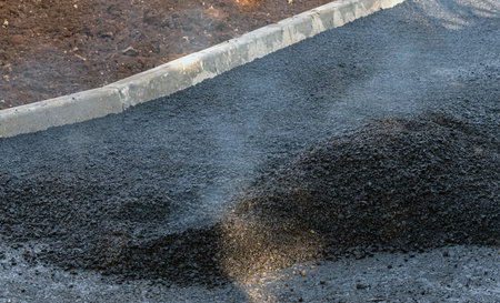 laying of new asphalt pavement on the roadの写真素材
