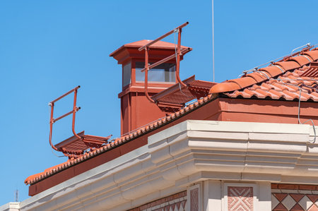 house with a roof from a red shingles with a pipe on background of blue skyの写真素材