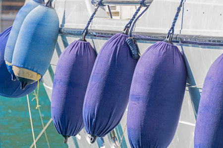 Small ship fenders hanging above pleasure yacht hull