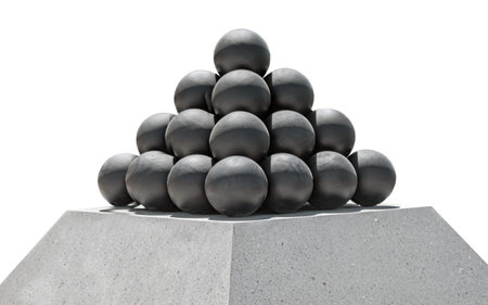 A pyramid of black cannonballs on a white background